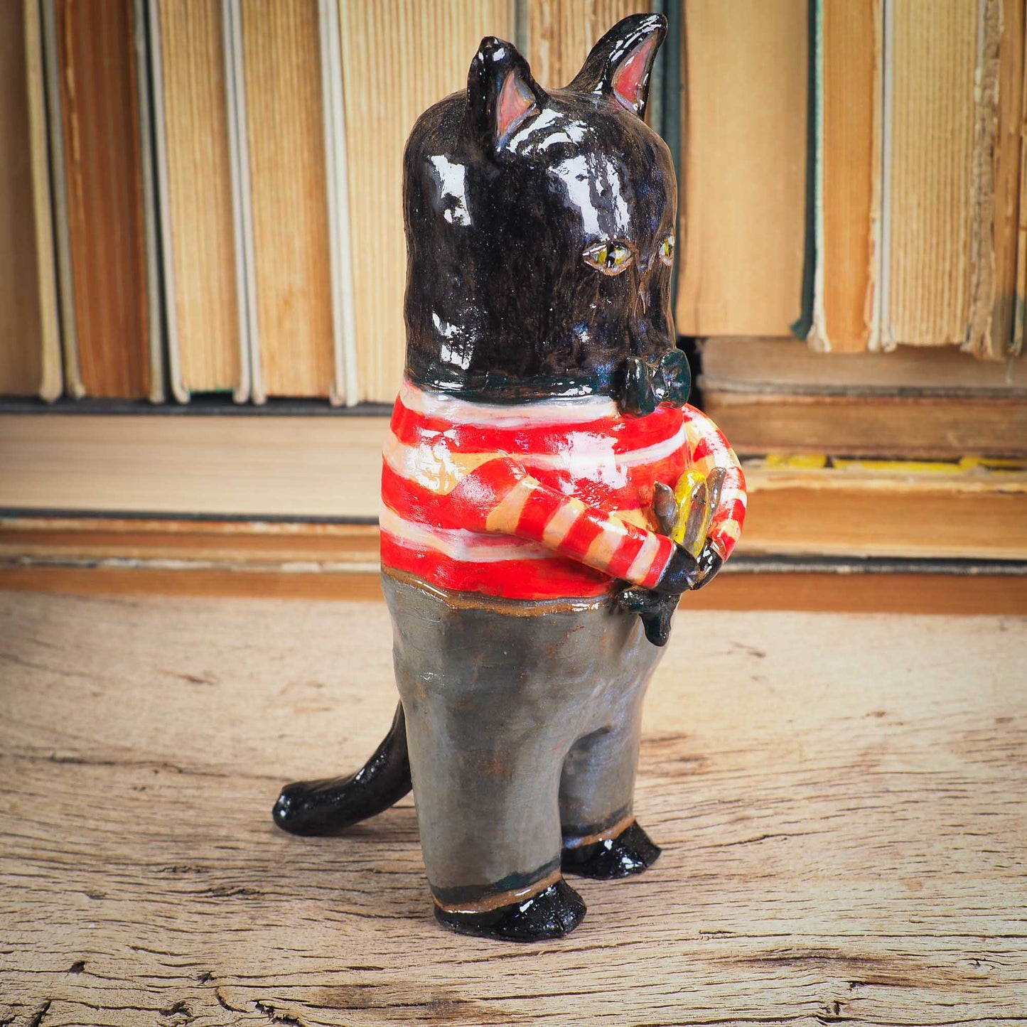 A handmade ceramic cat that loves fish... and mermaids! He is holding a cute little blond mermaid in his paws. Original ceramic sculpture by Idania Salcido.