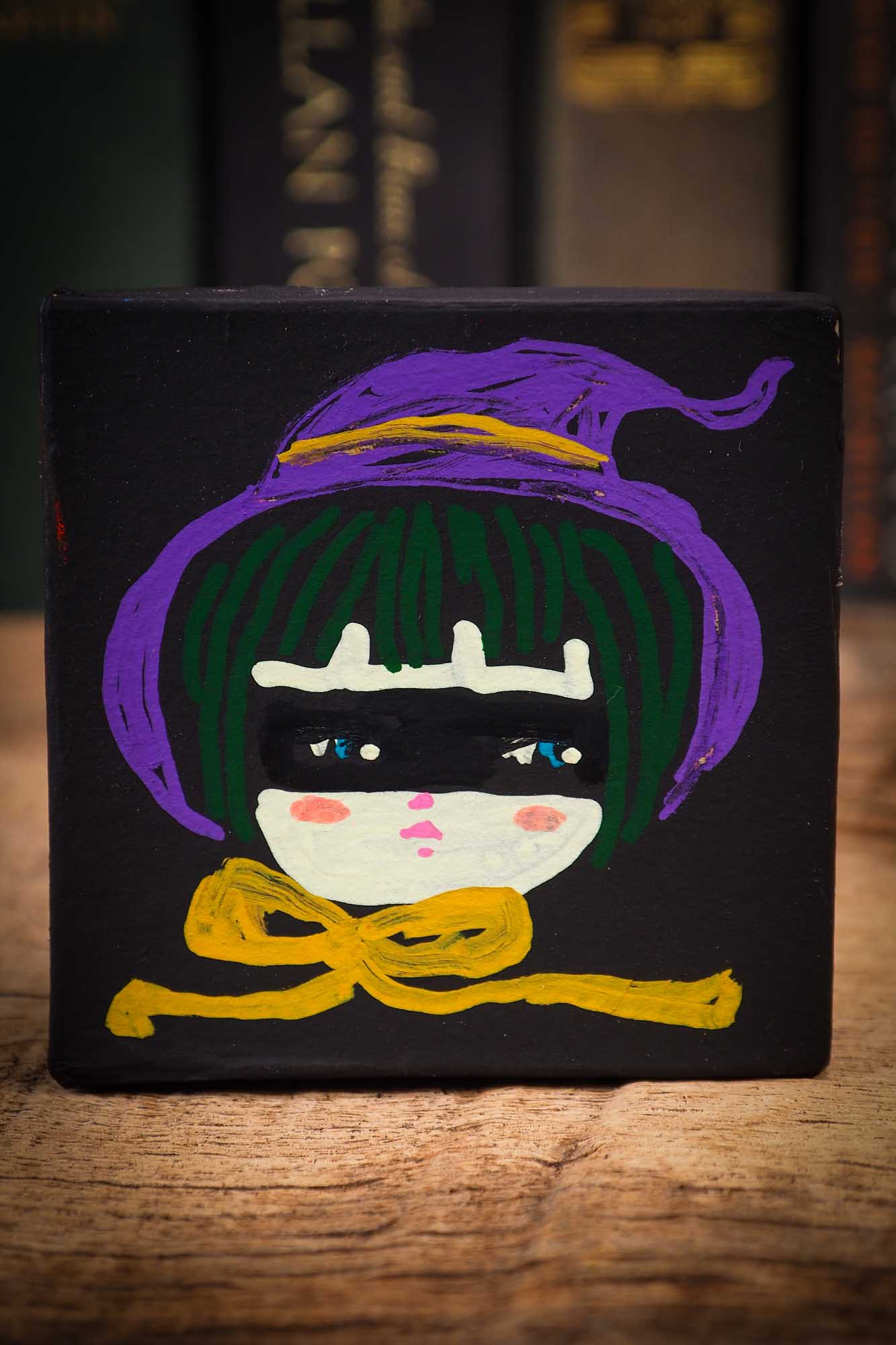 Small mini kokeshi Halloween art doll box with black hair, purple witch hat, and yellow scarf, made by Idania Salcido, the artist behind Danita Art.