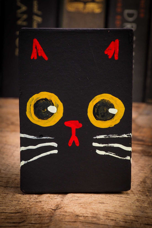 Small Halloween mini kokeshi art doll figurine with black cat face, orange and black striped body, purple and orange ribbon. Made by Idania Salcido, Danita Art.