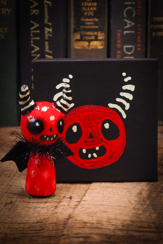 Small Halloween mini kokeshi art doll figurine with sculpted horned red devil head, striped horns, black wings and scarf. Made by Idania Salcido, Danita Art.