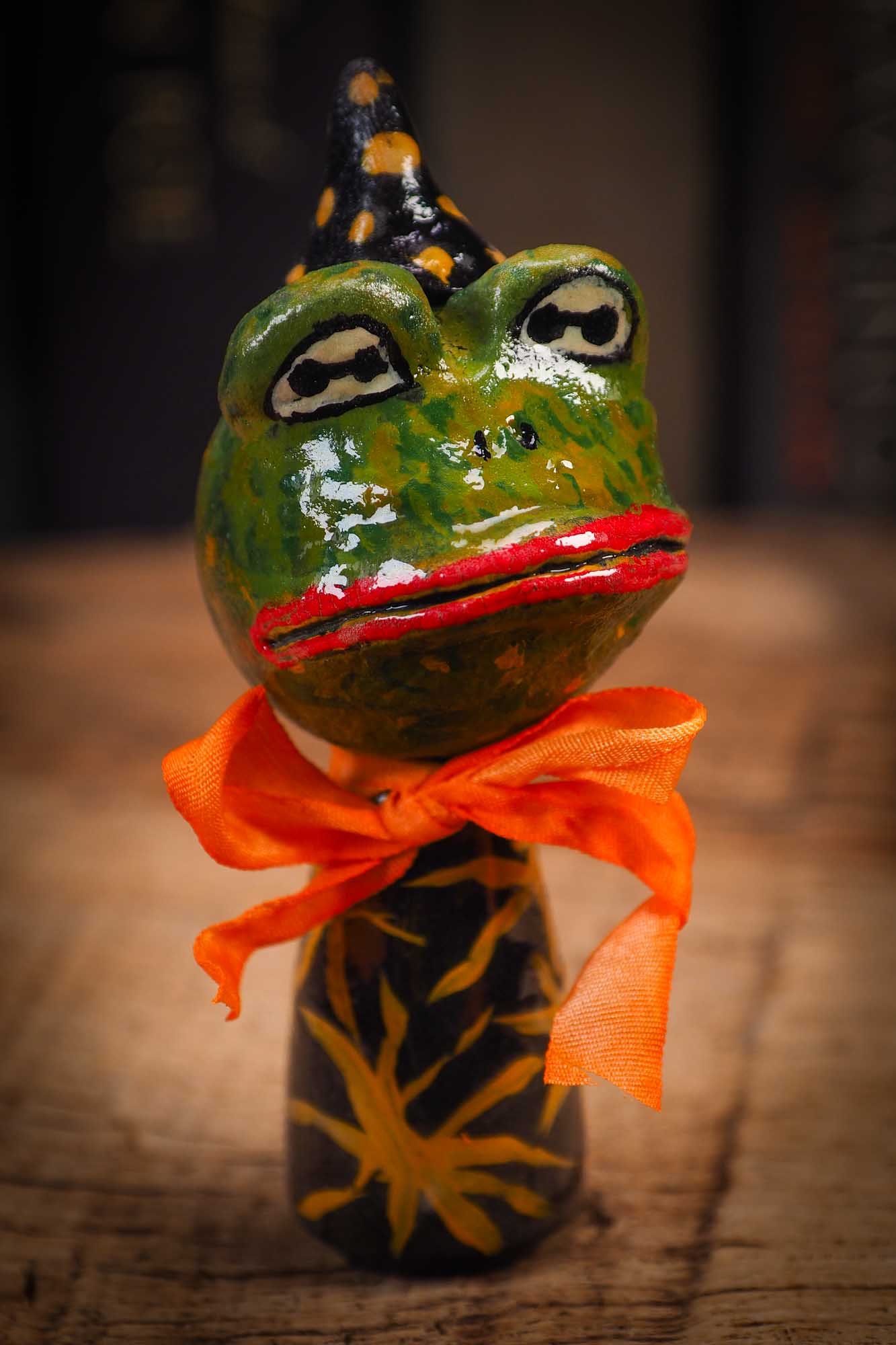 Small Halloween mini kokeshi art doll magic green toad wizard figurine with painted star body, orange silk bow. Made by Idania Salcido, Danita Art.