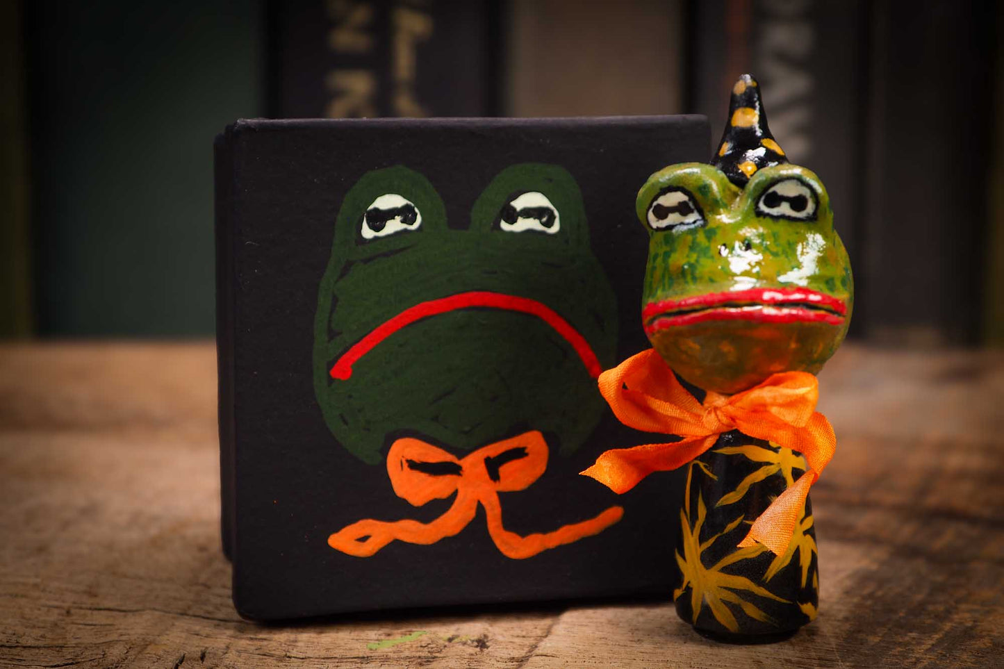 Small Halloween mini kokeshi art doll magic green toad wizard figurine with painted star body, orange silk bow. Made by Idania Salcido, Danita Art.