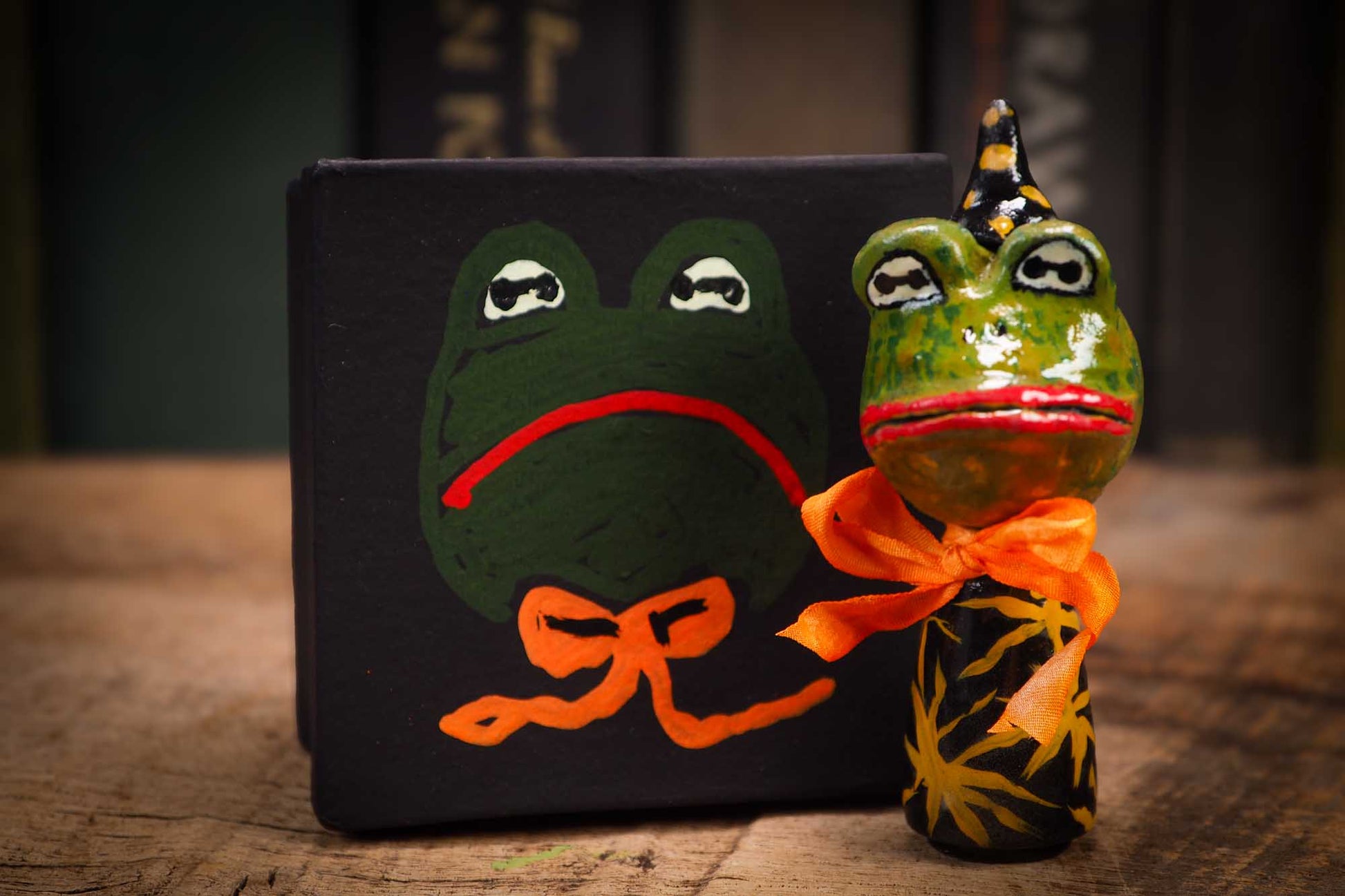 Small Halloween mini kokeshi art doll magic green toad wizard figurine with painted star body, orange silk bow. Made by Idania Salcido, Danita Art.