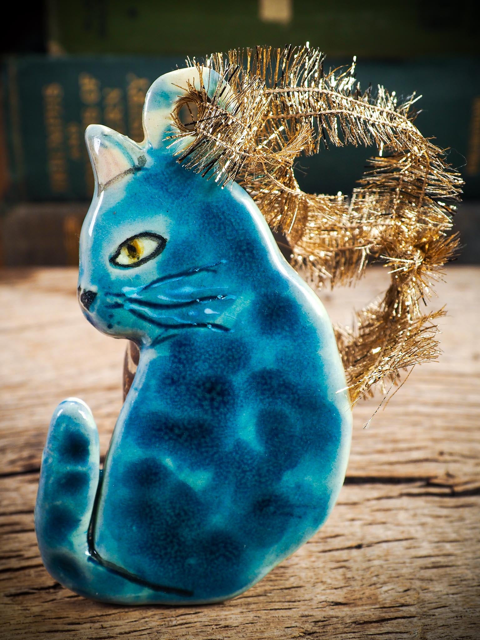 Handmade ceramic blue cat ornament with painted face and curled tail, created by Idania Salcido Danita Art for holiday decoration or gifting.