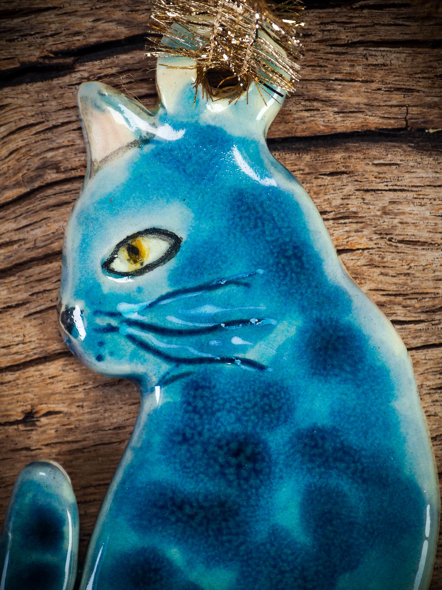 Handmade ceramic blue cat ornament with painted face and curled tail, created by Idania Salcido Danita Art for holiday decoration or gifting.