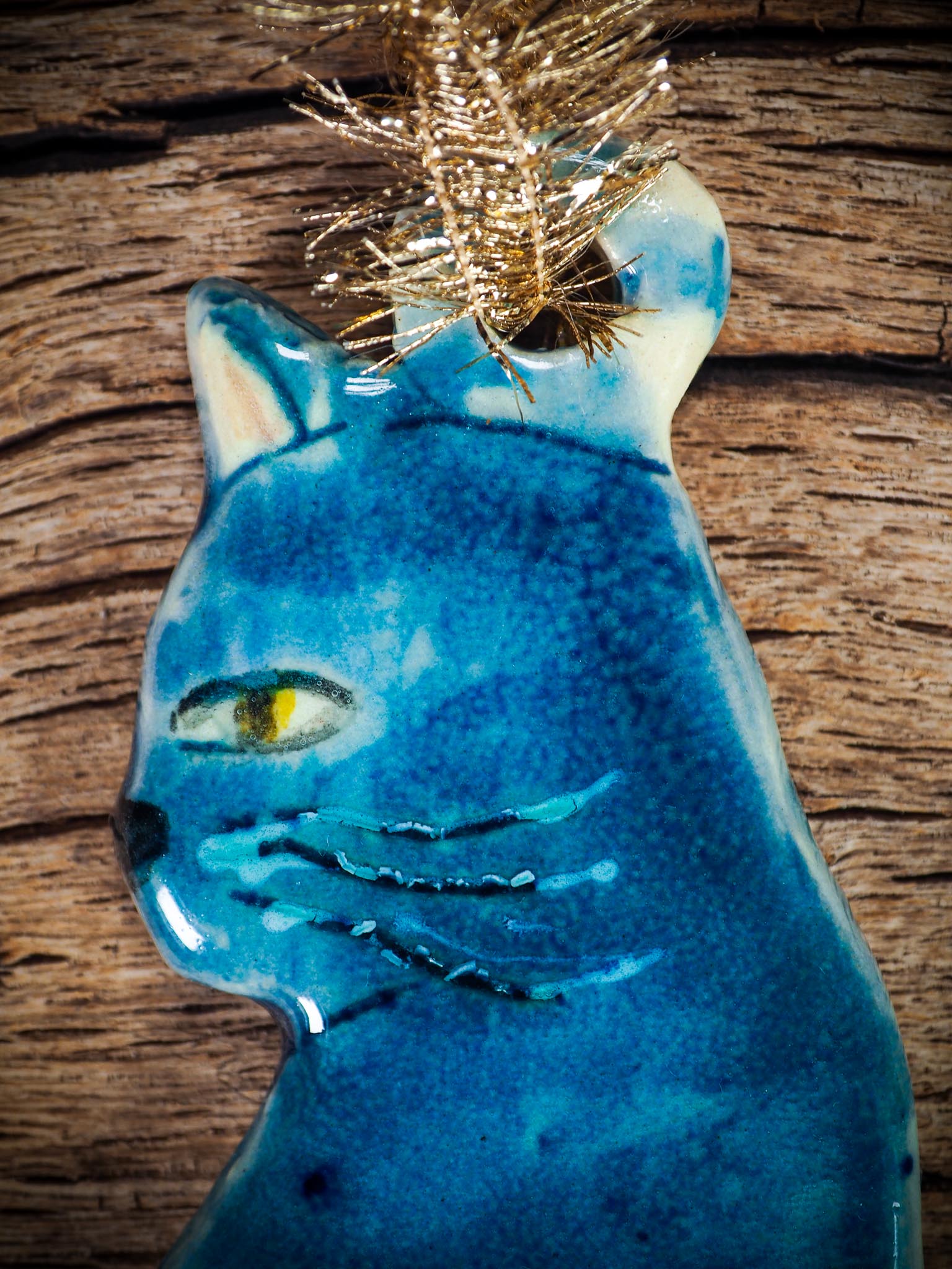 Handmade ceramic blue cat ornament with painted face and curled tail, created by Idania Salcido Danita Art for holiday decoration or gifting.