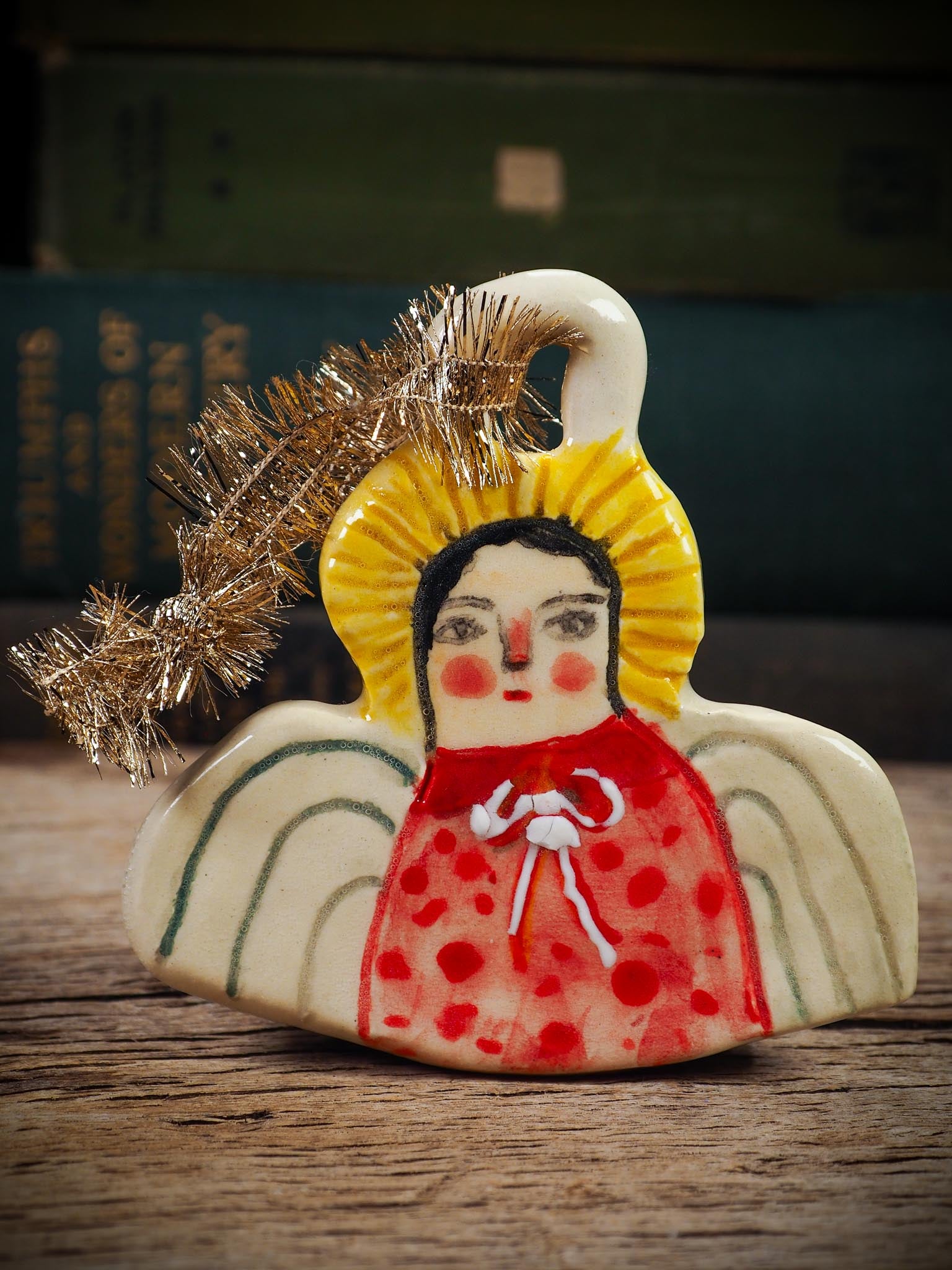 Handmade ceramic angel ornament with painted face, wings, and halo, created by Idania Salcido Danita Art for Christmas decorating or gifting.