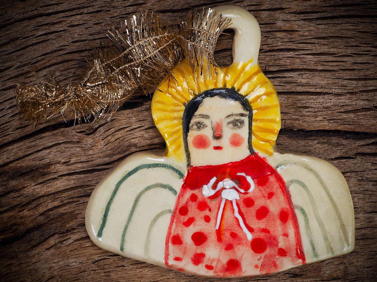 Handmade ceramic angel ornament with painted face, wings, and halo, created by Idania Salcido Danita Art for Christmas decorating or gifting.