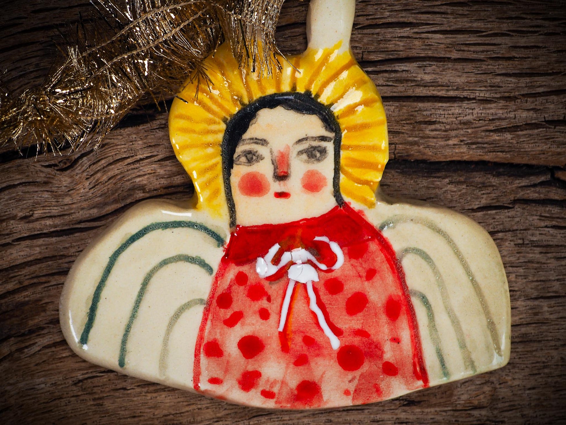 Handmade ceramic angel ornament with painted face, wings, and halo, created by Idania Salcido Danita Art for Christmas decorating or gifting.