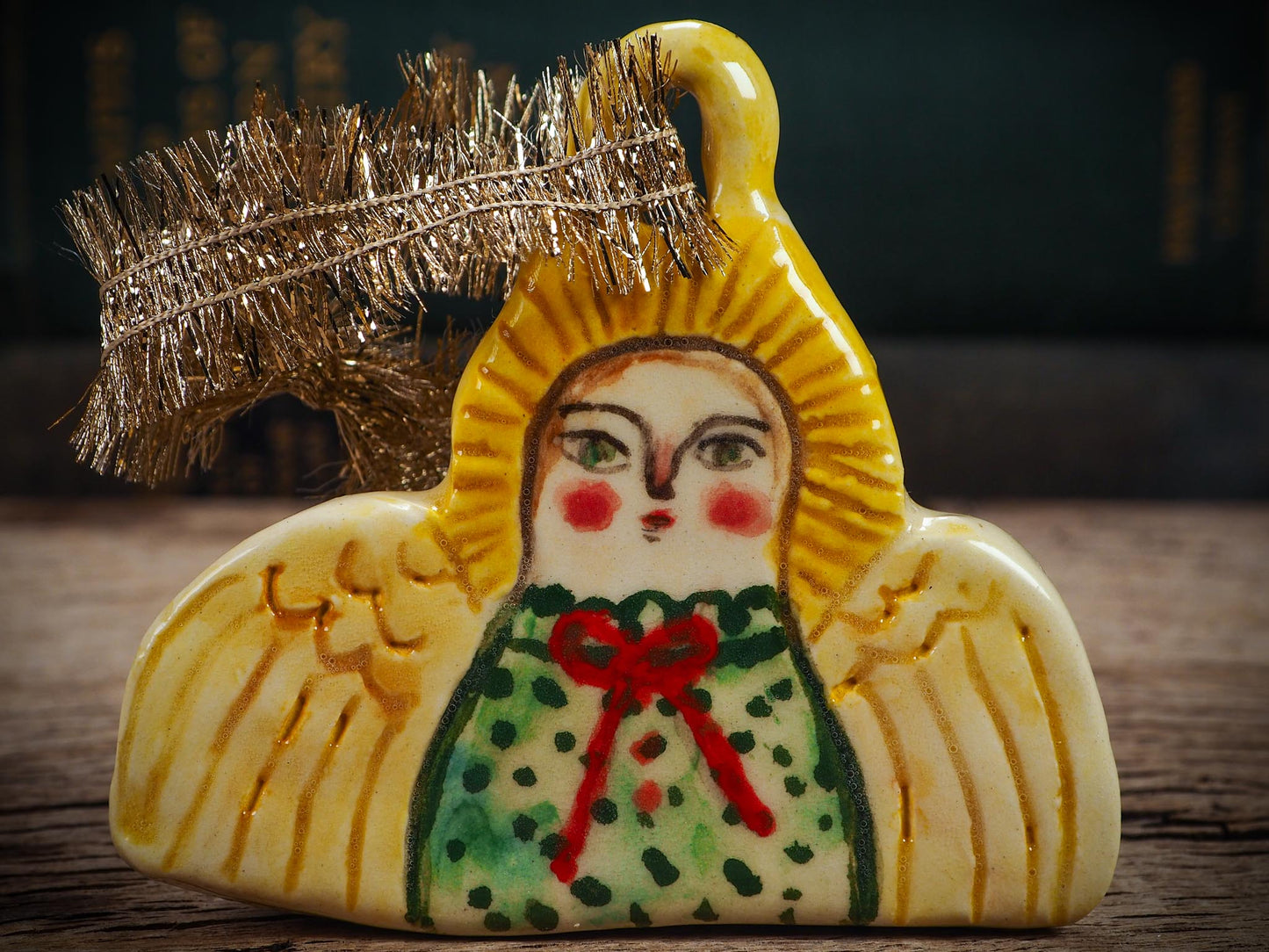 Handmade ceramic angel ornament with painted face, wings, and halo, created by Idania Salcido Danita Art for Christmas decorating or gifting.