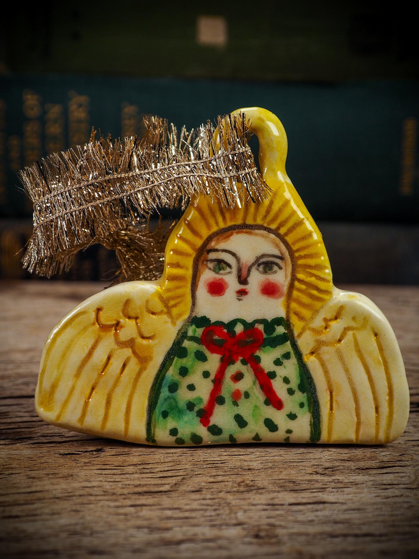 Handmade ceramic angel ornament with painted face, wings, and halo, created by Idania Salcido Danita Art for Christmas decorating or gifting.