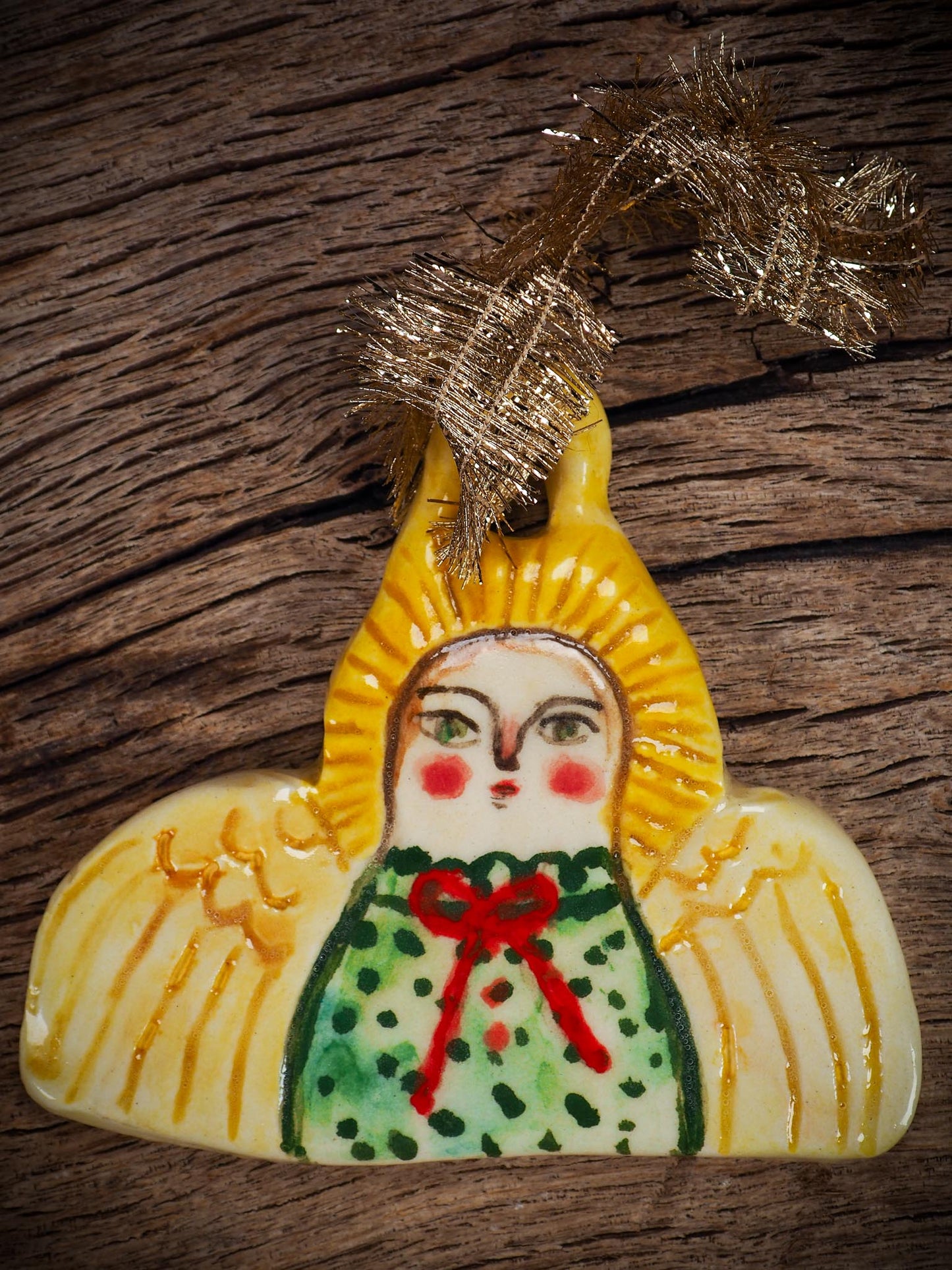 Handmade ceramic angel ornament with painted face, wings, and halo, created by Idania Salcido Danita Art for Christmas decorating or gifting.
