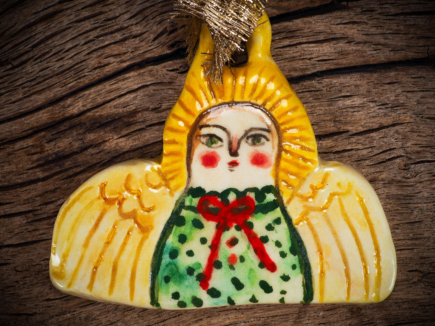 Handmade ceramic angel ornament with painted face, wings, and halo, created by Idania Salcido Danita Art for Christmas decorating or gifting.