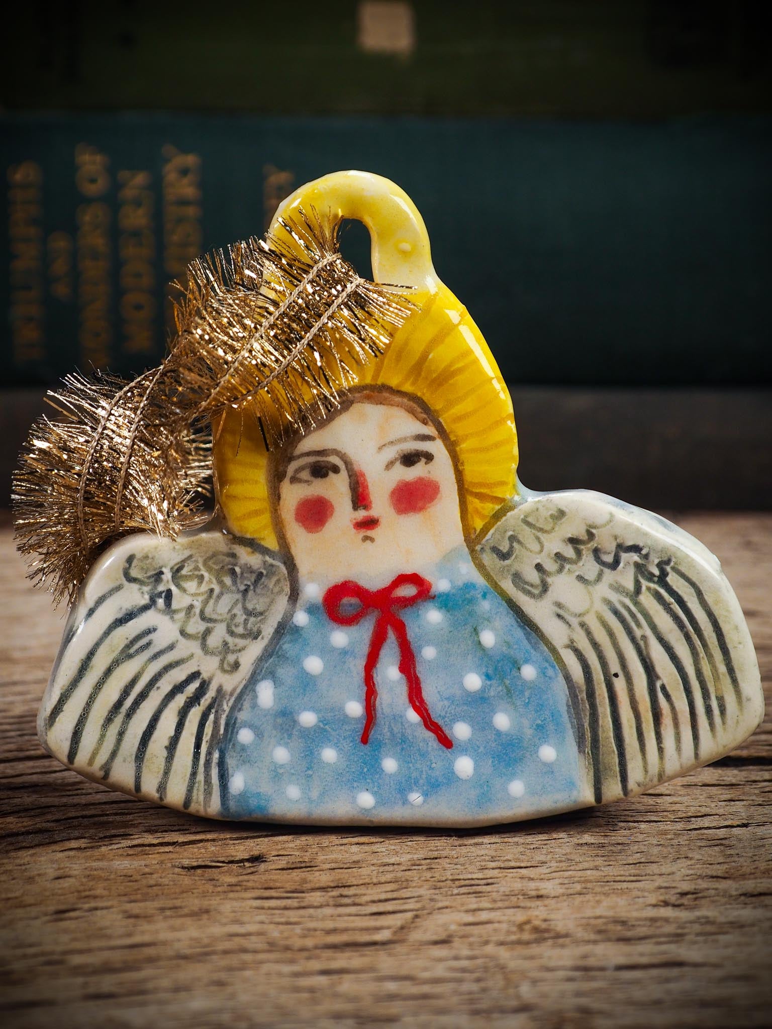 Handmade ceramic angel ornament with painted face, wings, and halo, created by Idania Salcido Danita Art for Christmas decorating or gifting.
