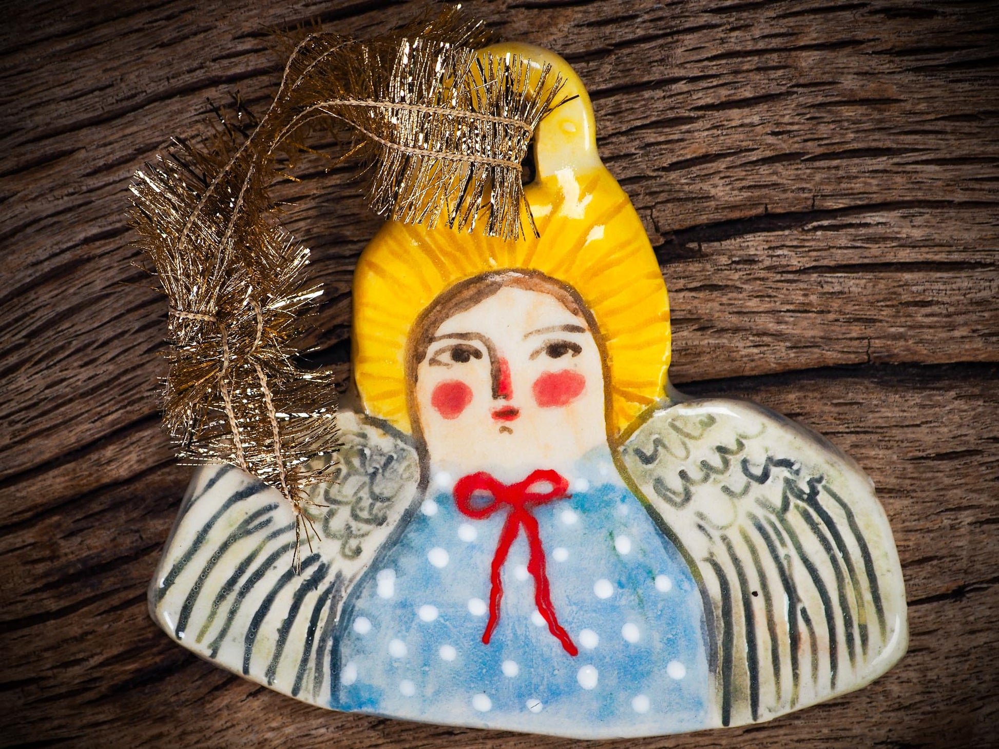 Handmade ceramic angel ornament with painted face, wings, and halo, created by Idania Salcido Danita Art for Christmas decorating or gifting.