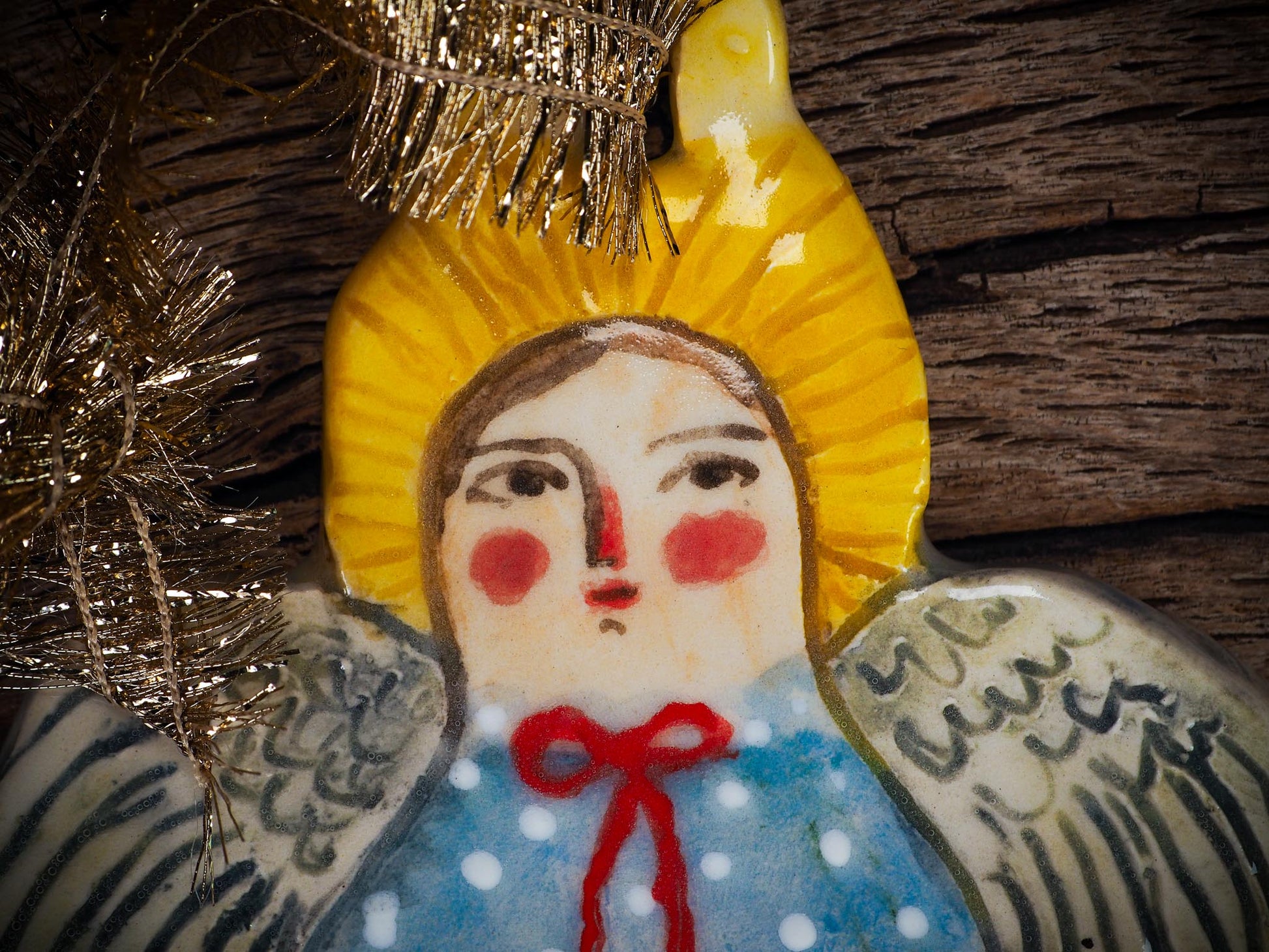 Handmade ceramic angel ornament with painted face, wings, and halo, created by Idania Salcido Danita Art for Christmas decorating or gifting.
