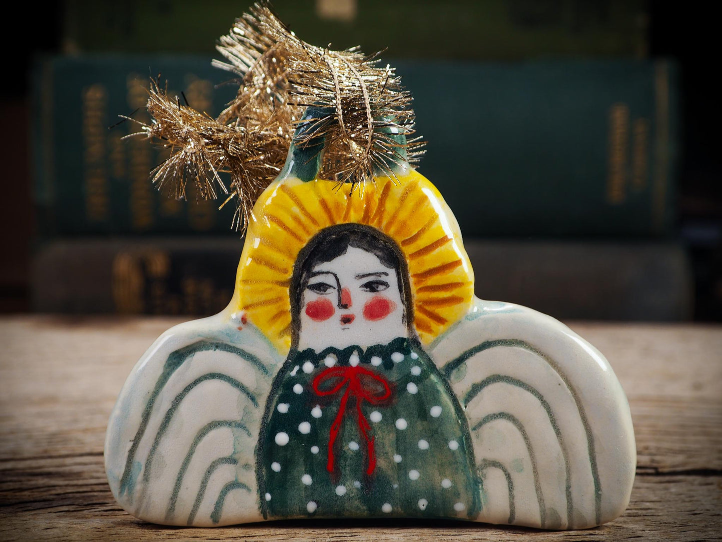 Handmade ceramic angel ornament with painted face, wings, and halo, created by Idania Salcido Danita Art for Christmas decorating or gifting.