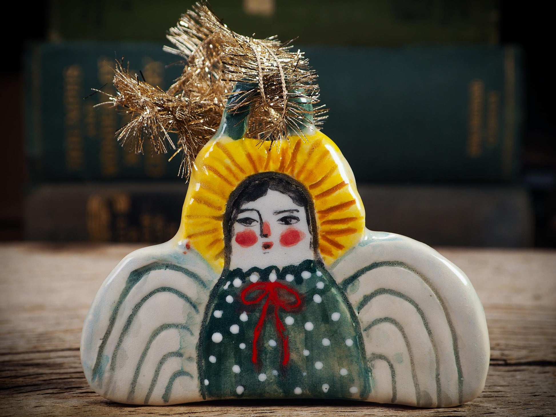 Handmade ceramic angel ornament with painted face, wings, and halo, created by Idania Salcido Danita Art for Christmas decorating or gifting.