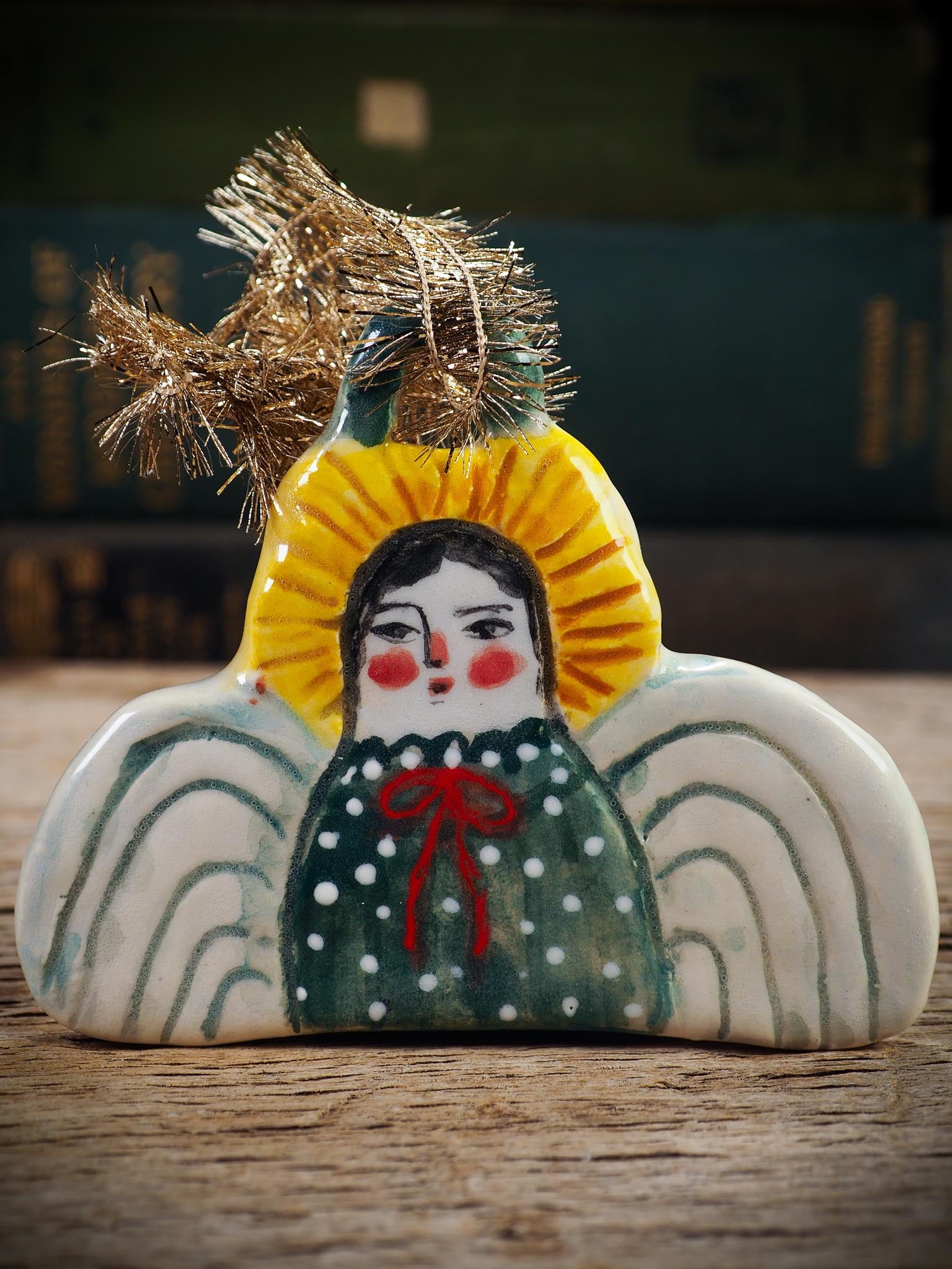 Handmade ceramic angel ornament with painted face, wings, and halo, created by Idania Salcido Danita Art for Christmas decorating or gifting.