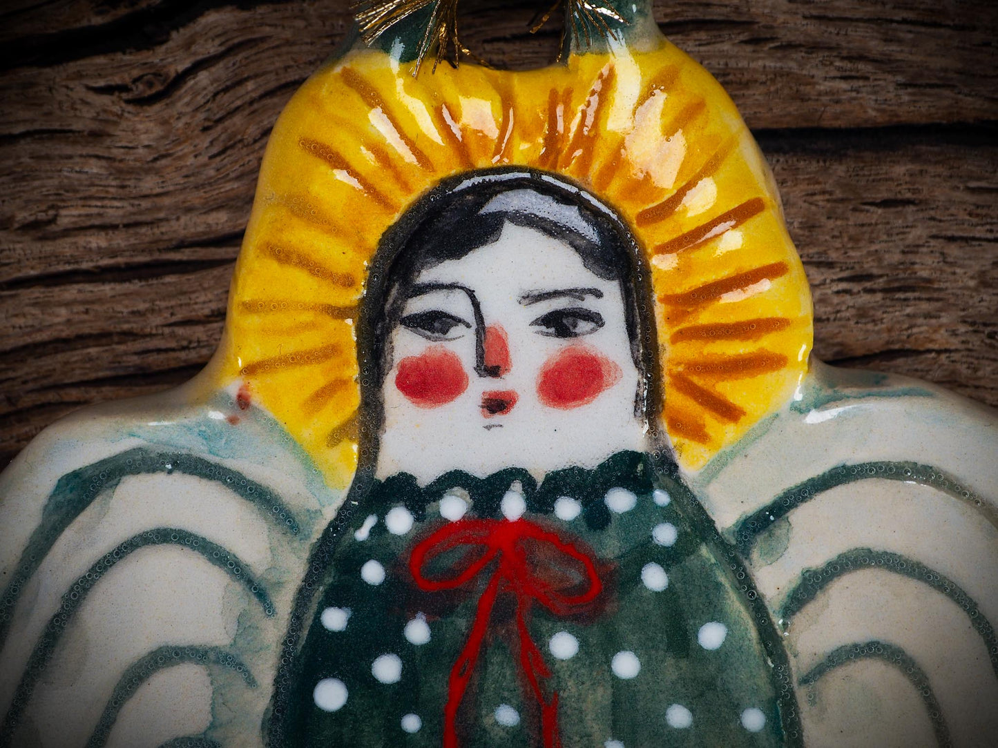 Handmade ceramic angel ornament with painted face, wings, and halo, created by Idania Salcido Danita Art for Christmas decorating or gifting.