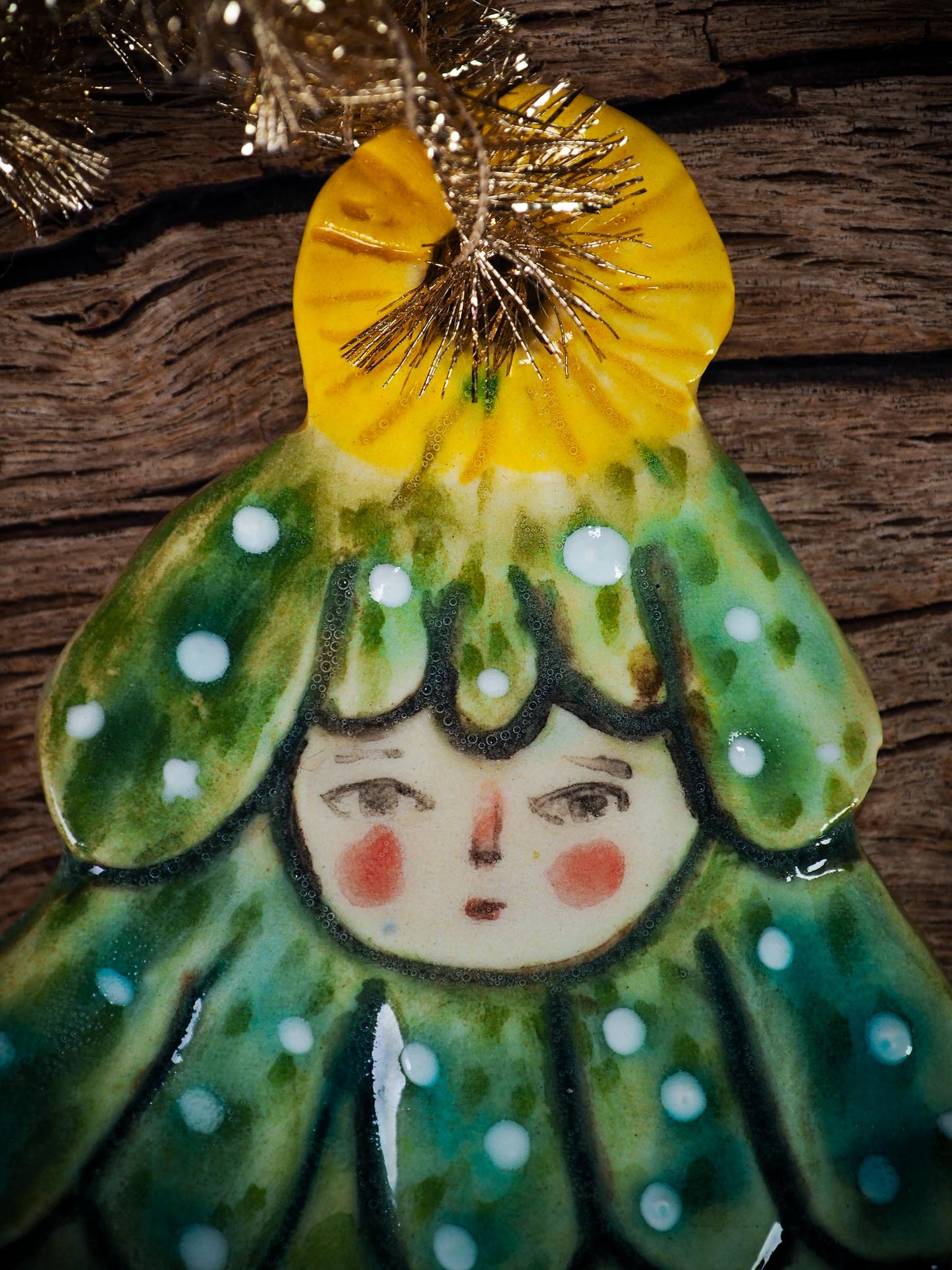 Handmade ceramic Christmas tree figure ornament with painted face and snowy details, created by Idania Salcido Danita Art for holiday decoration or gifting.