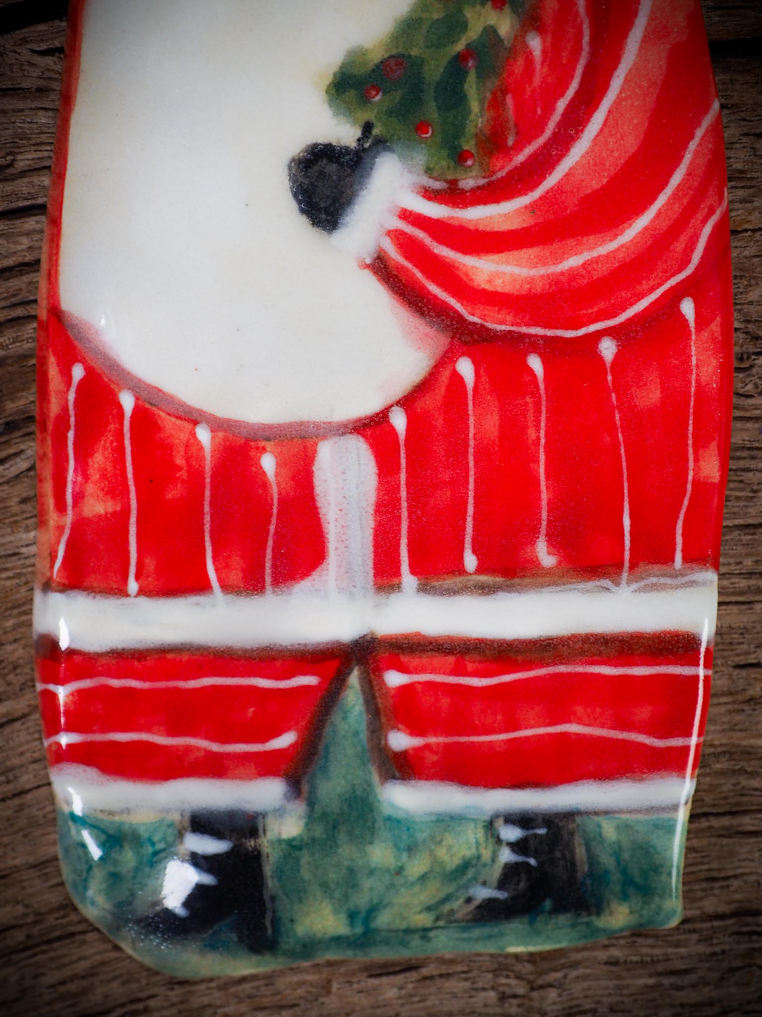 Handmade ceramic Santa figure ornament with red coat and ribbon, created by Danita Art for Christmas decoration or gifting.