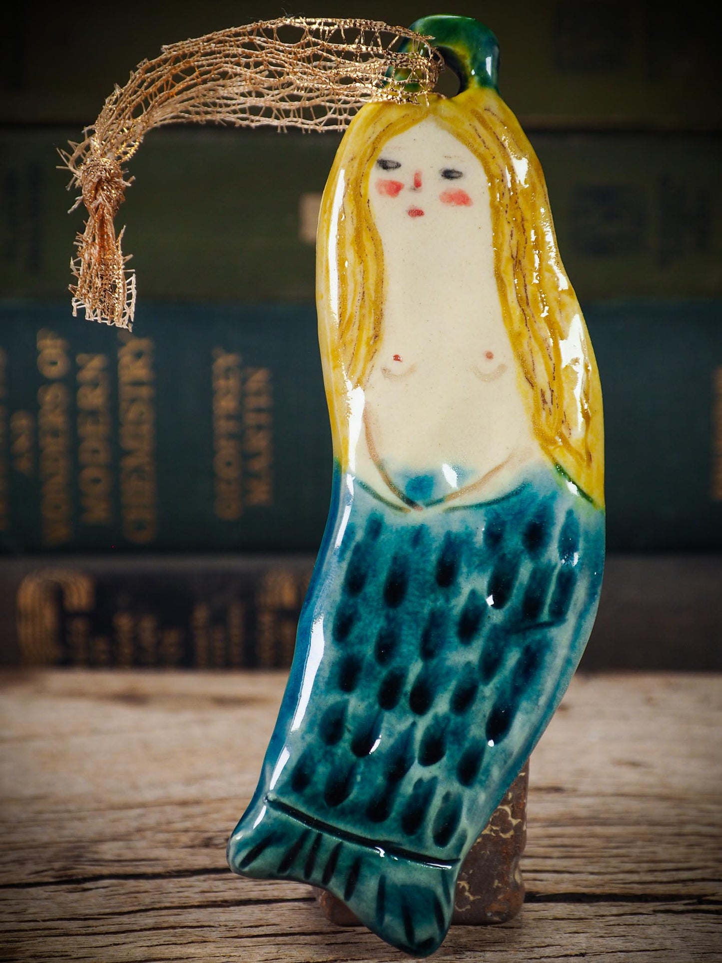 Handmade ceramic mermaid ornament with golden hair and blue-green tail, created by Idania Salcido aka Danita Art for holiday decorating or gifting.