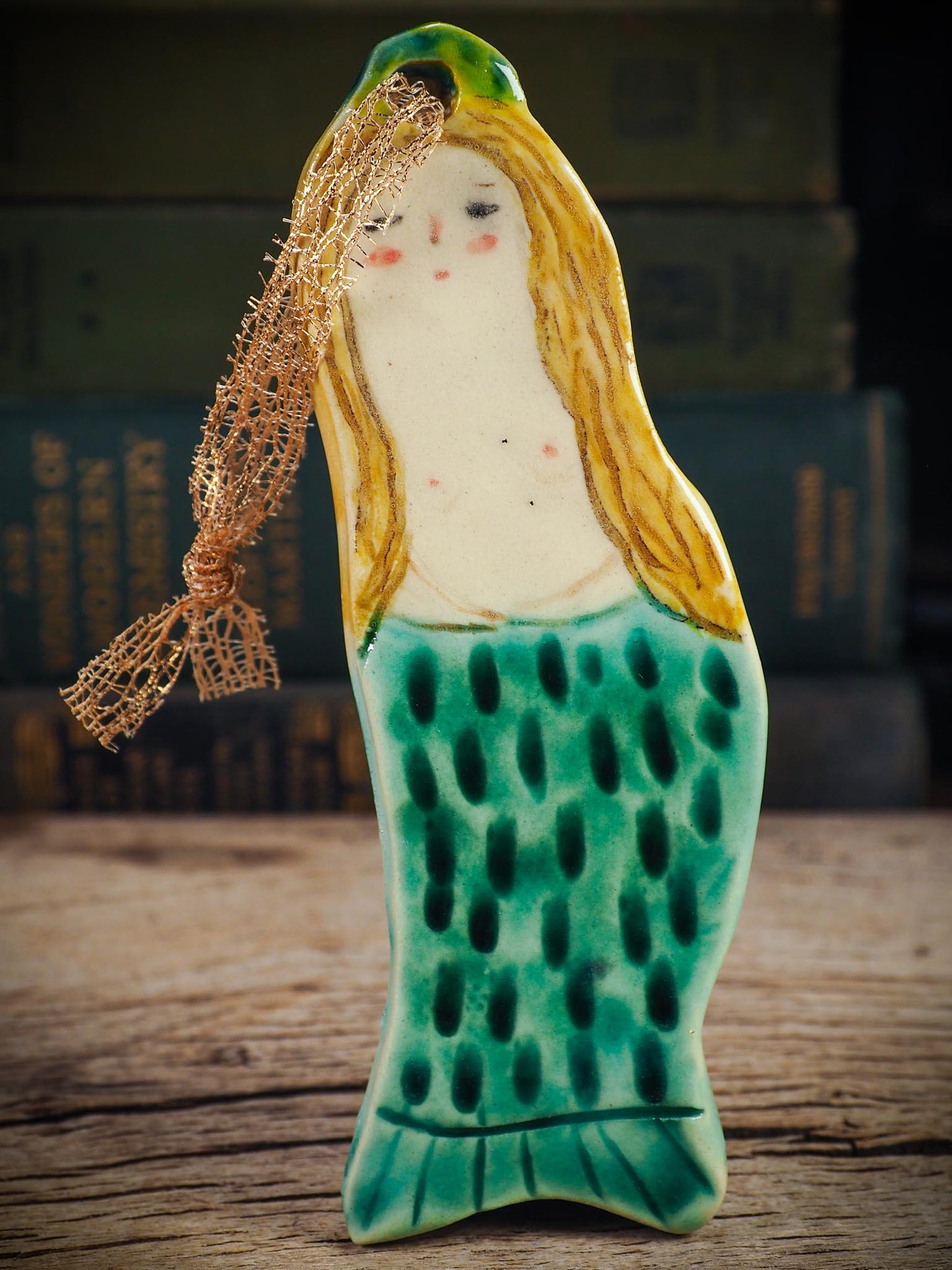 Handmade ceramic mermaid ornament with golden hair and blue-green tail, created by Idania Salcido aka Danita Art for holiday decorating or gifting.
