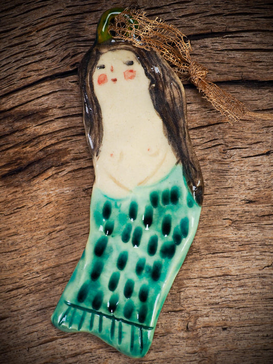 Handmade ceramic mermaid ornament with golden hair and blue-green tail, created by Idania Salcido aka Danita Art for holiday decorating or gifting.