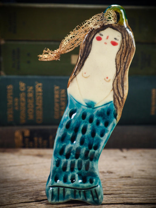 Handmade ceramic mermaid ornament with golden hair and blue-green tail, created by Idania Salcido aka Danita Art for holiday decorating or gifting.