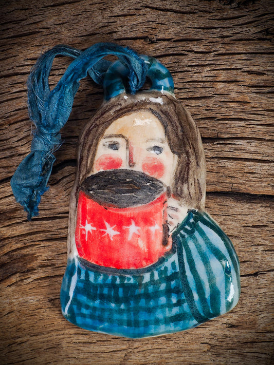 Handmade ceramic hot cocoa woman figure ornament with red mug and blue clothing, created by Idania Salcido aka Danita Art for Christmas decorating or gifting.