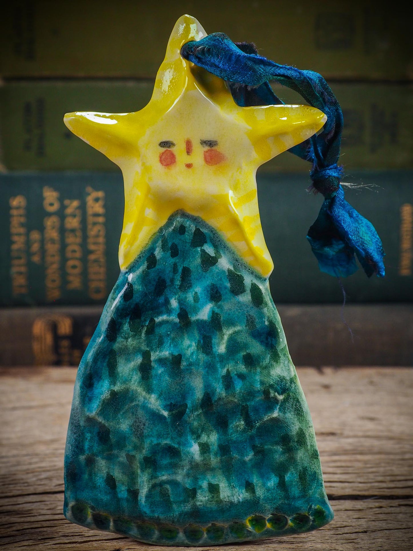 Handmade ceramic star figure ornament with painted face and blue-green gown, created by Idania Salcido Danita Art for Christmas decorating or gifting.