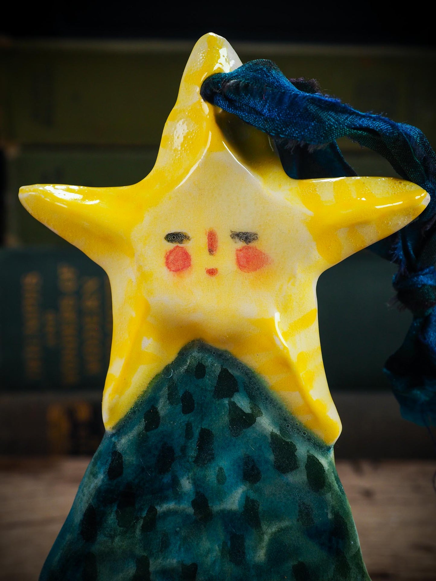 Handmade ceramic star figure ornament with painted face and blue-green gown, created by Idania Salcido Danita Art for Christmas decorating or gifting.
