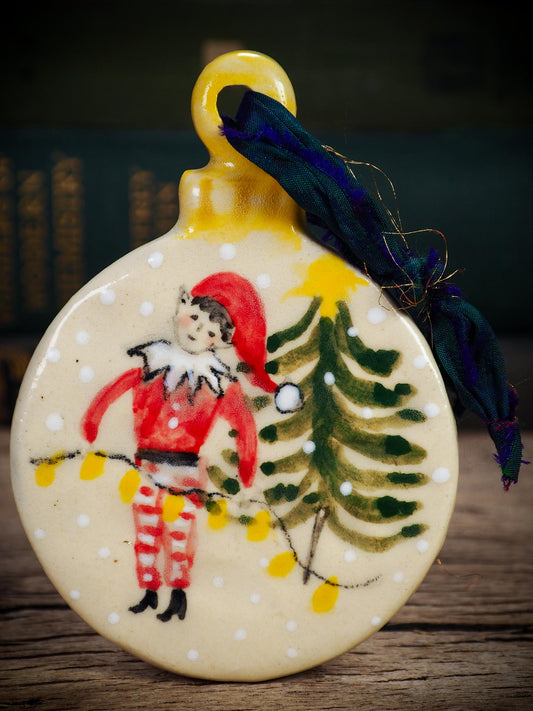 Handmade ceramic elf ornament with tree and holiday lights, created by Idania Salcido aka Danita Art for Christmas decorating or gifting.