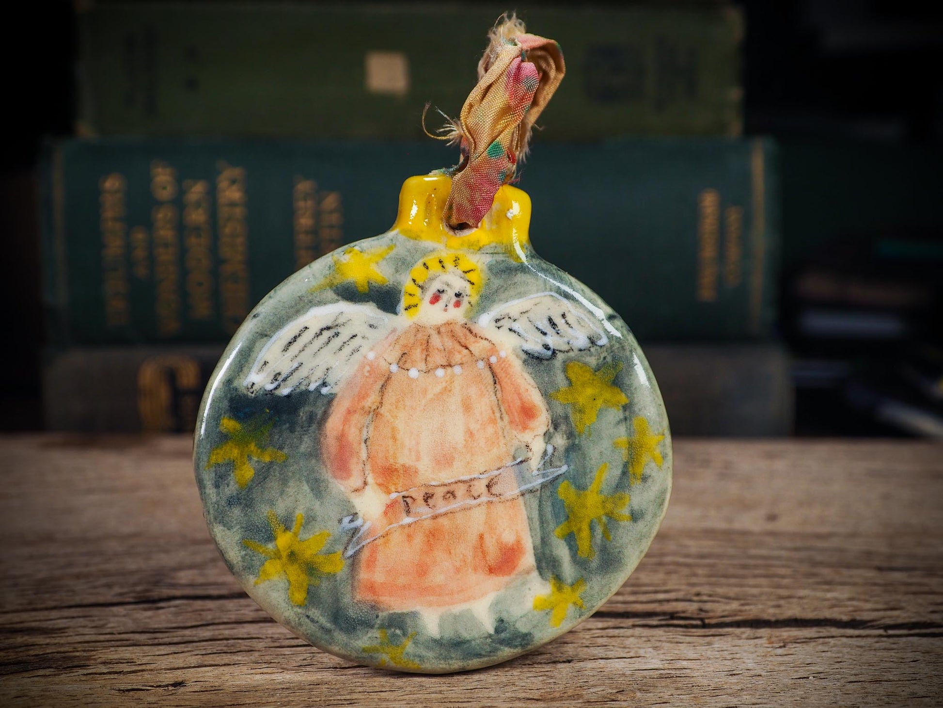 Handmade ceramic Peace Angel ornament with wings and golden halo, created by Idania Salcido aka Danita Art for Christmas decorating or gifting.