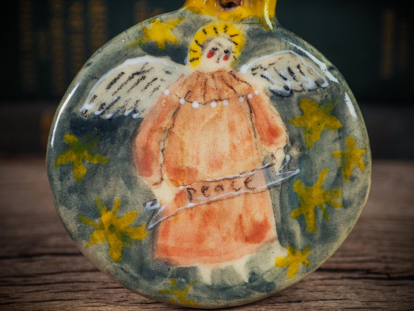 Handmade ceramic Peace Angel ornament with wings and golden halo, created by Idania Salcido aka Danita Art for Christmas decorating or gifting.