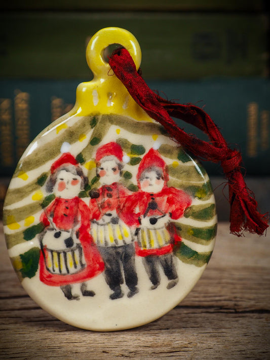 Handmade ceramic Little Drummers ornament with red outfits and yellow drums, created by Idania Salcido aka Danita Art for Christmas decorating or gifting.