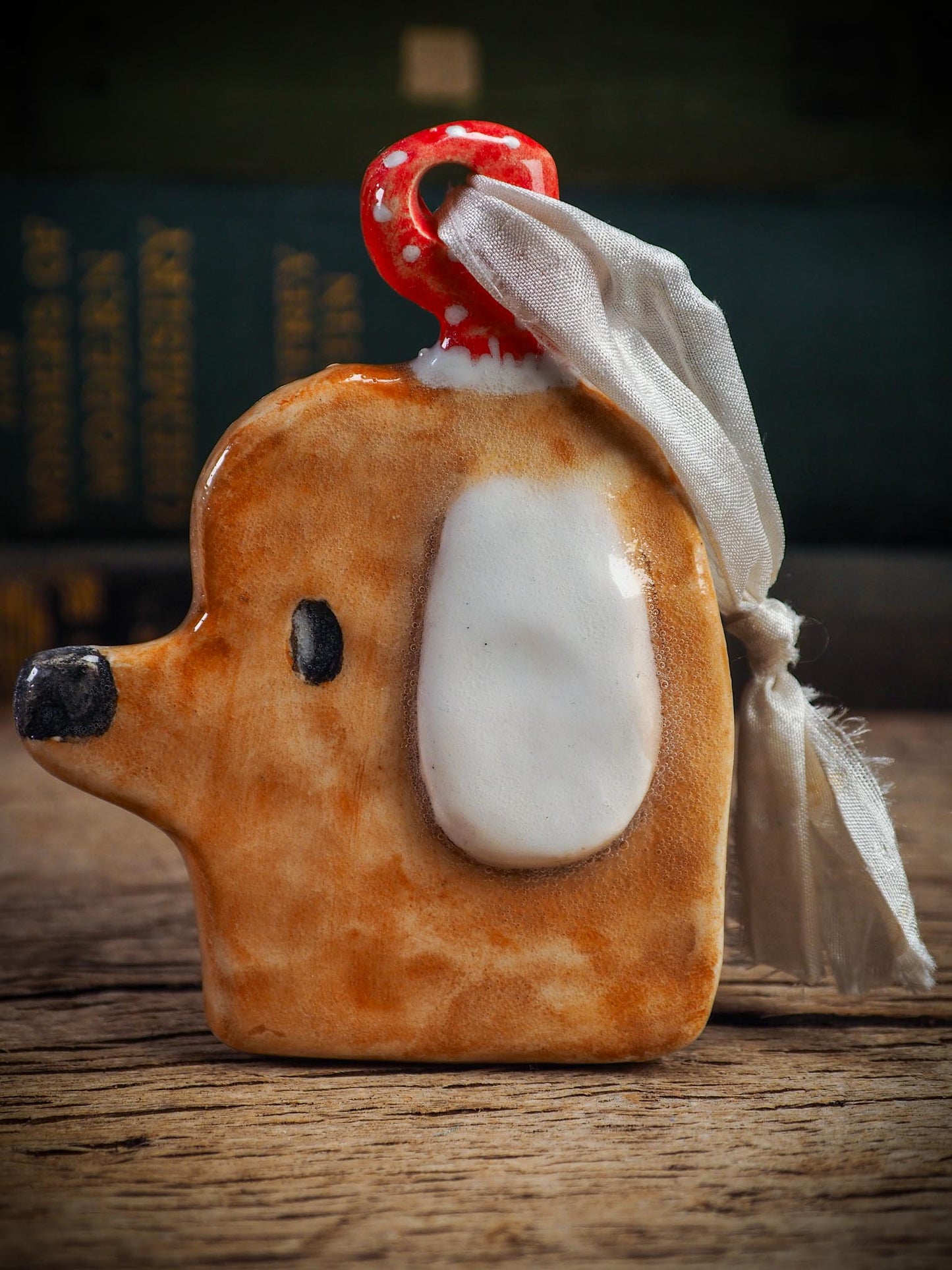 Handmade ceramic dog ornament with winter hoodie, created by Idania Salcido aka Danita Art for Christmas decorating or gifting.