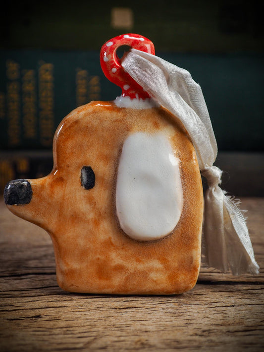 Handmade ceramic dog ornament with winter hoodie, created by Idania Salcido aka Danita Art for Christmas decorating or gifting.