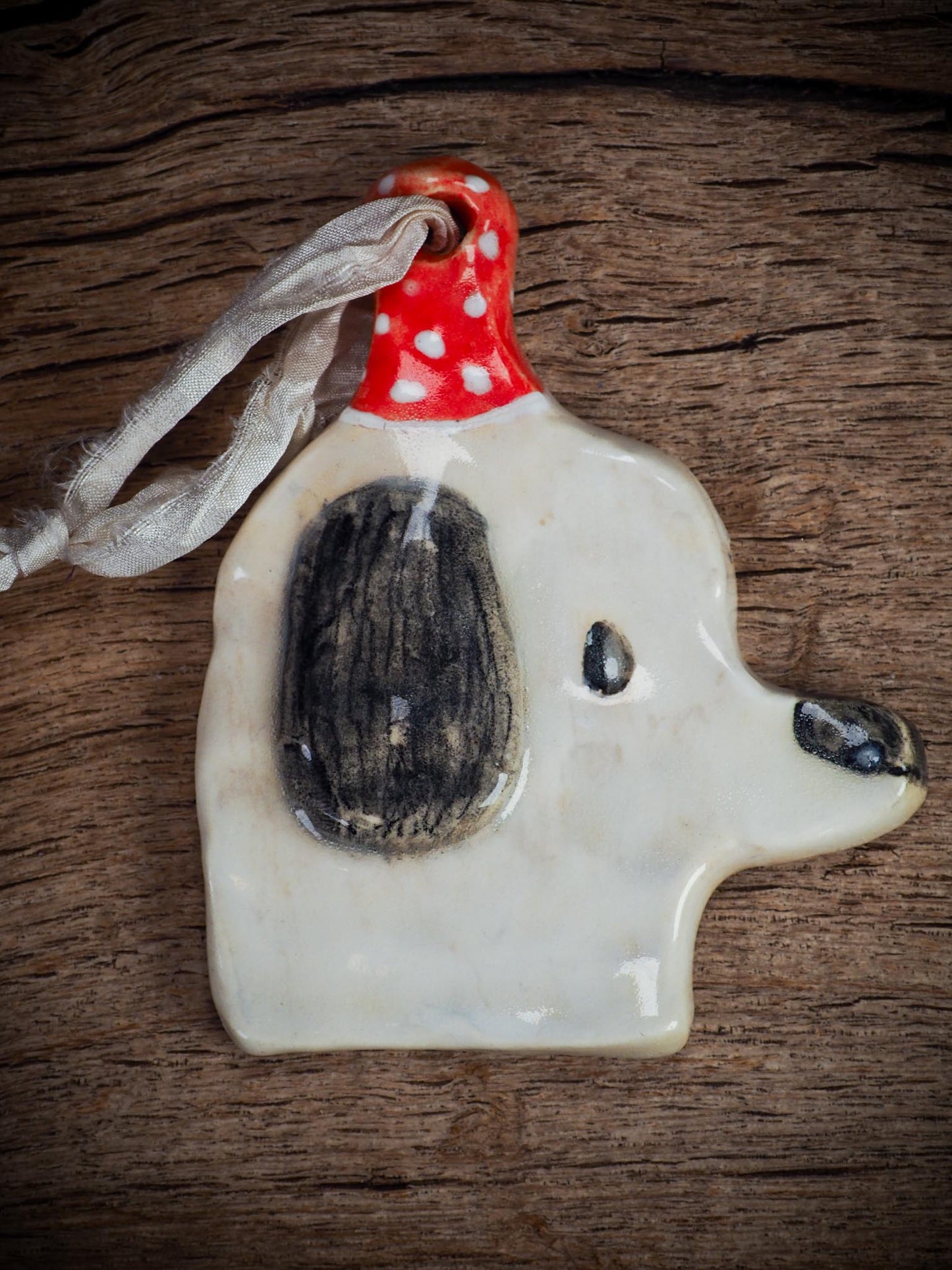 Handmade ceramic dog ornament with winter hoodie, created by Idania Salcido aka Danita Art for Christmas decorating or gifting.