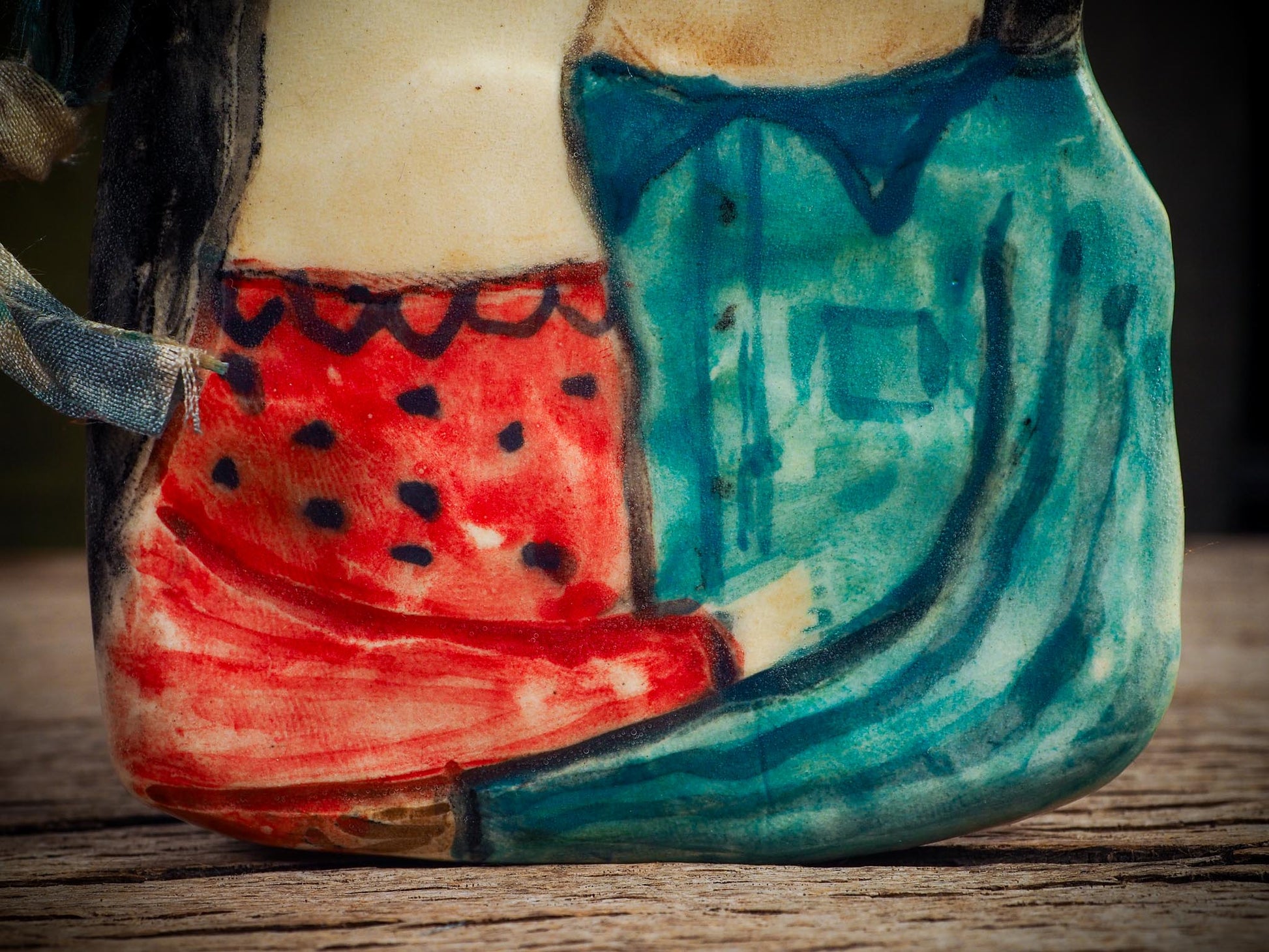 Handmade ceramic winter couple ornament with painted scarves and ribbon, created by Idania Salcido aka Danita Art for Christmas decoration or gifting.