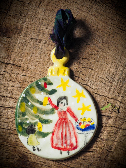 Handmade ceramic ornament of a mother and child decorating a Christmas tree by Idania Salcido aka Danita Art.