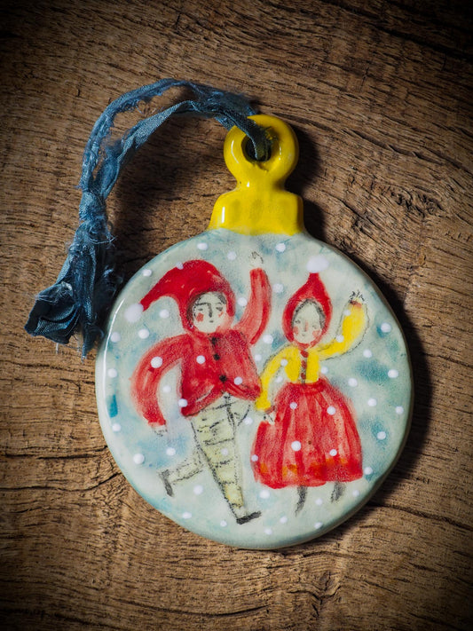 Handmade ceramic ornament with two dancing Christmas elves by Idania Salcido aka Danita Art.