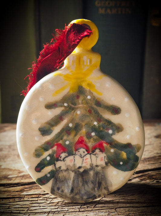 Handmade ceramic ornament of carolers under a Christmas tree by Idania Salcido aka Danita Art.