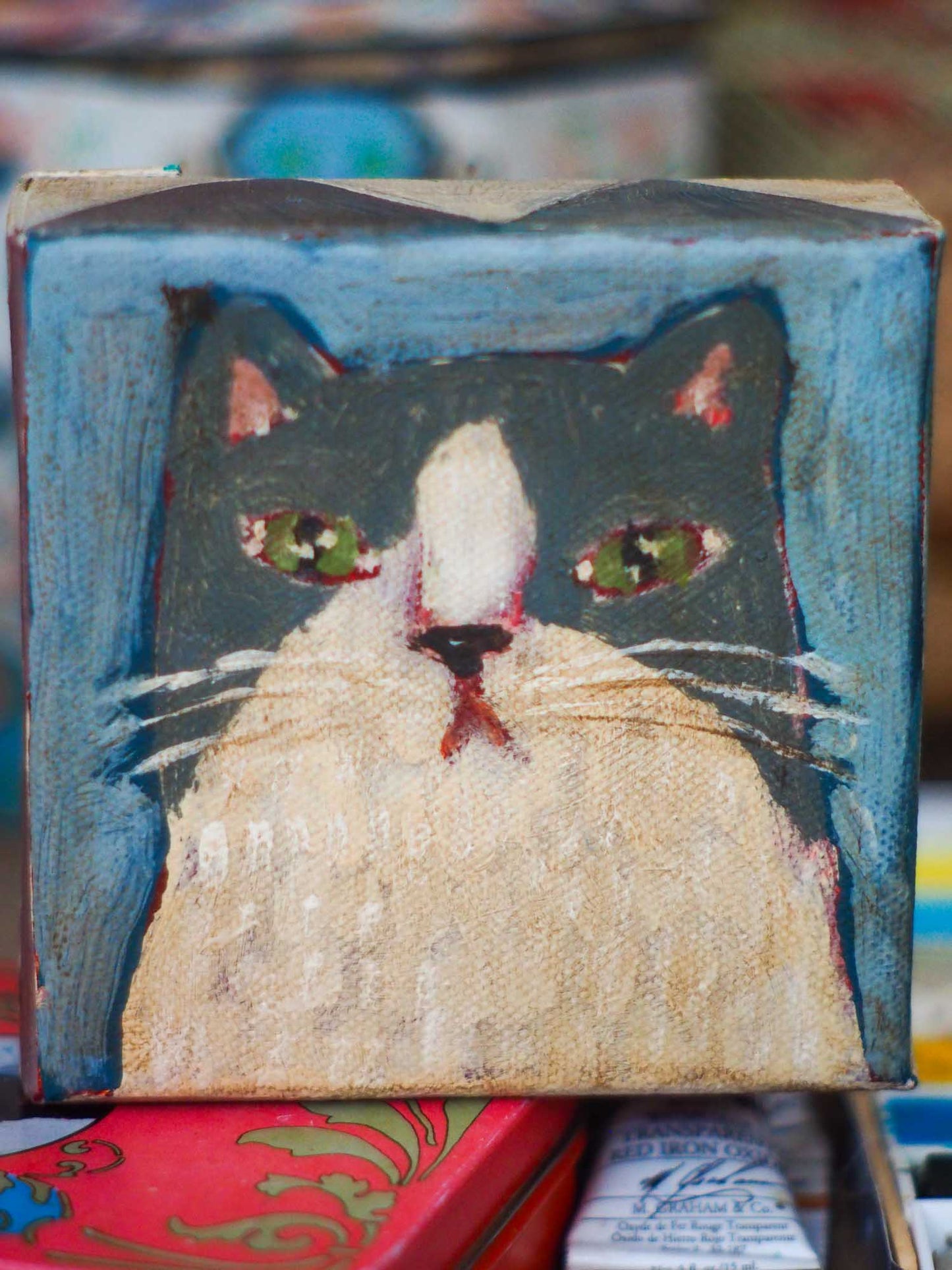 An original acrylic painting by Idania Salcido, Danita Art, depicting a grey cat posing on a serious pose. A cat doing cat things.