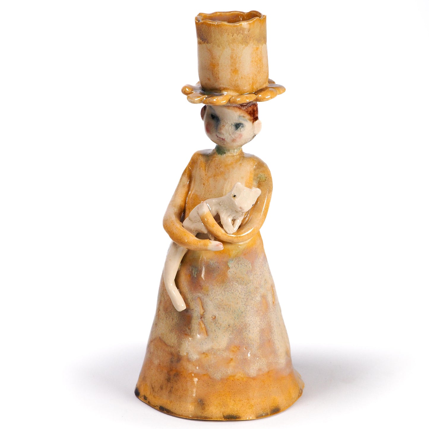 A vintage-style ceramic figurine of a woman in a tall hat holding a white cat, by Idania Salcido (Danita Art) with a small candle holder on top of her hat, on a white background.