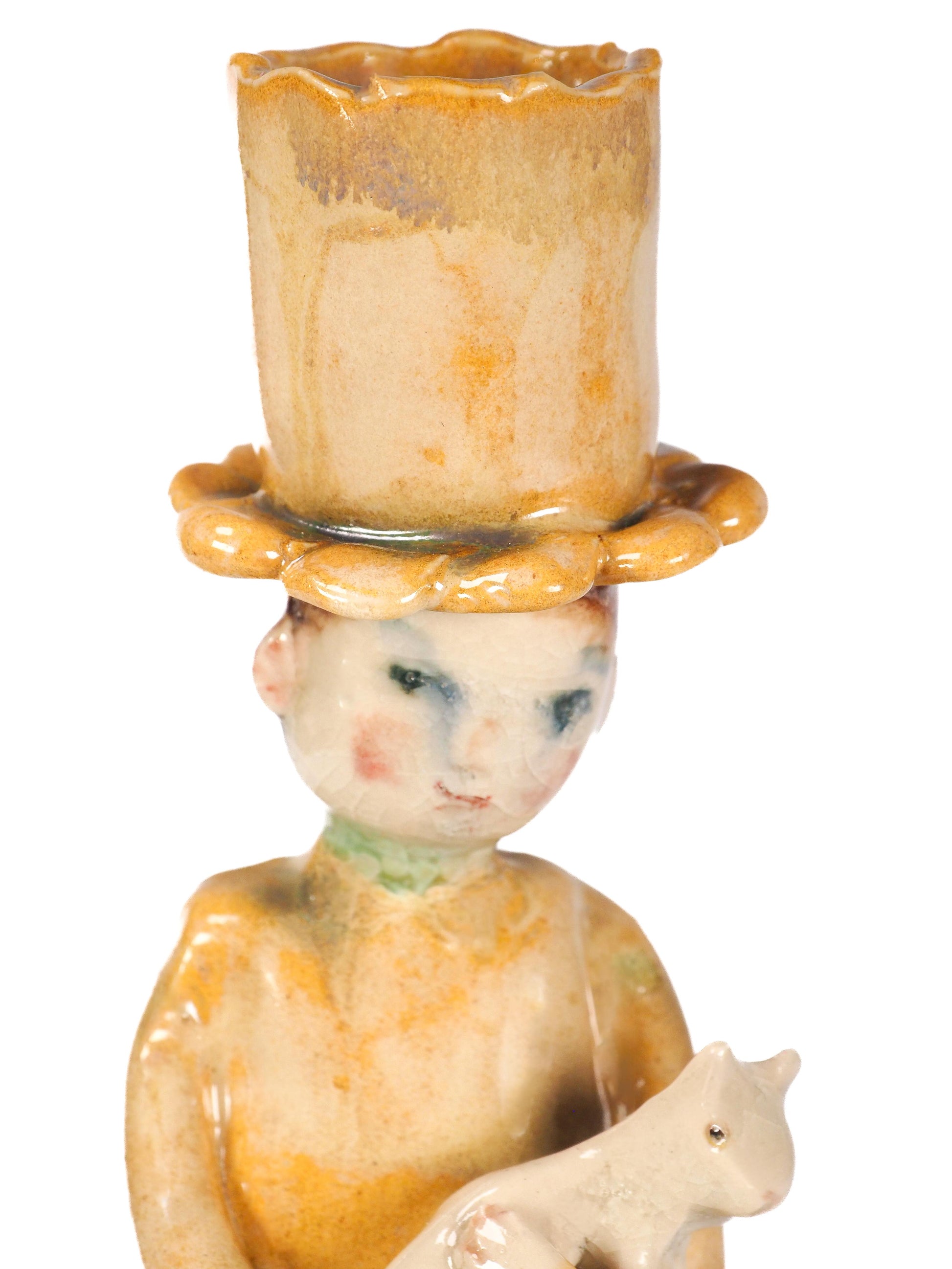 A vintage ceramic figurine of a child wearing a tall, scalloped top hat and holding a small cream-colored cat, by Idania Salcido (Danita Art).