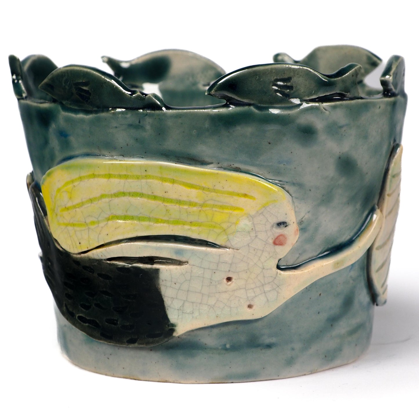 A handmade ceramic fish-shaped bowl with a dark green glazed finish, featuring a large yellow and white fish motif on the front and smaller fish protruding from the rim by Idania Salcido (Danita Art).