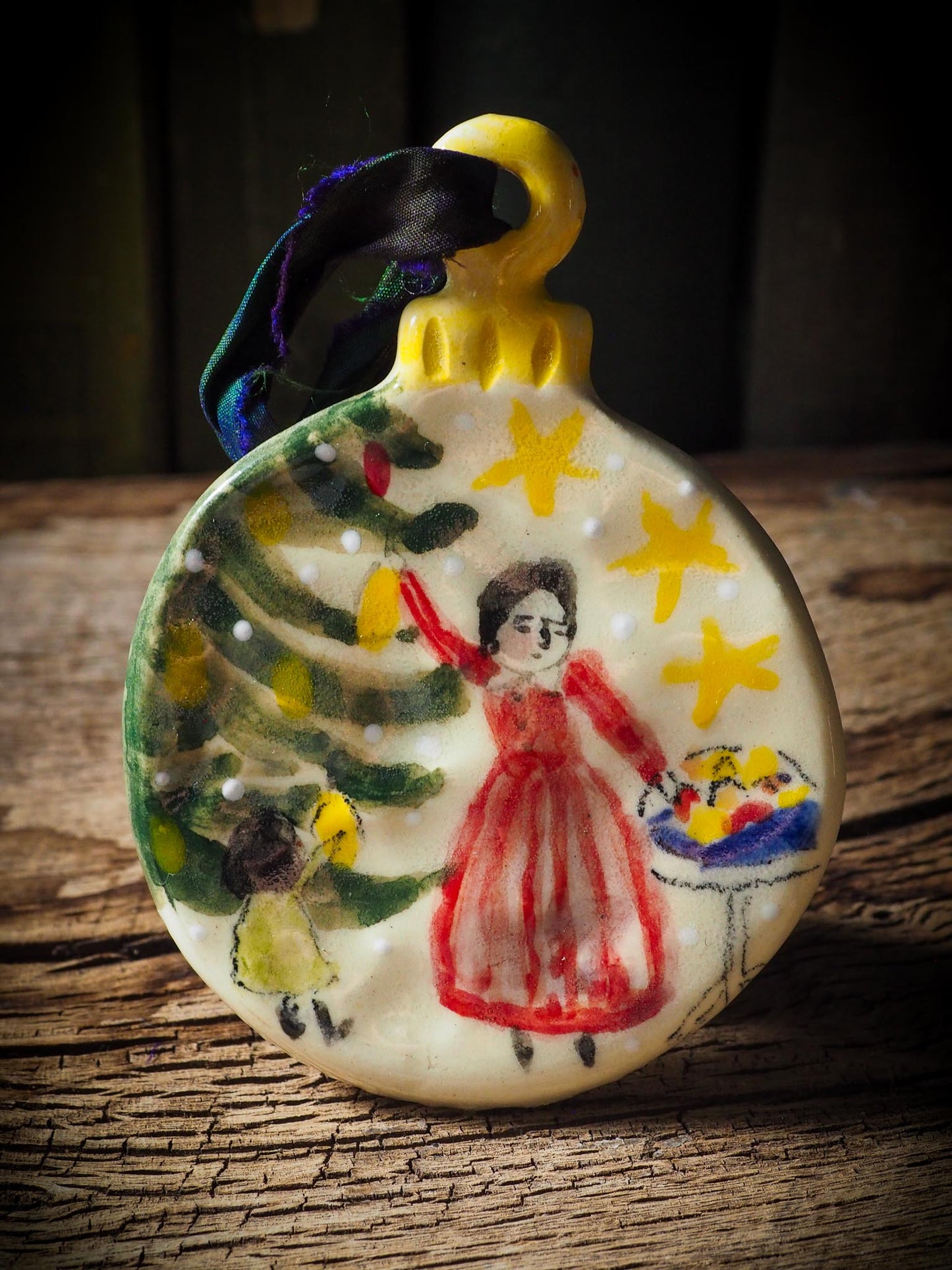 Handmade ceramic ornament of a mother and child decorating a Christmas tree by Idania Salcido aka Danita Art.