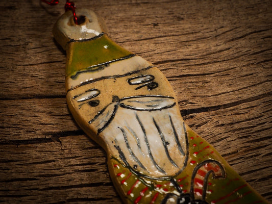 An original Christmas Holiday tree round glazed ceramic ornament handmade by Idania Salcido, the artist behind Danita Art. Glazed carved sgraffito stoneware, hand painted and decorated, it is illustrated by hand with snowmen, Christmas trees, Santa Claus, angels and snow balls and winter themes.